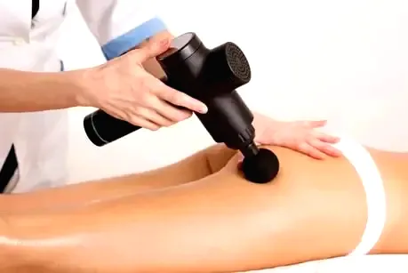 une experte de la sante qui utilise le masazas pistole contre la cellulite sur une femme Veselības eksperts,kas izmanto masāžas pistoli pret celulītu sievietei